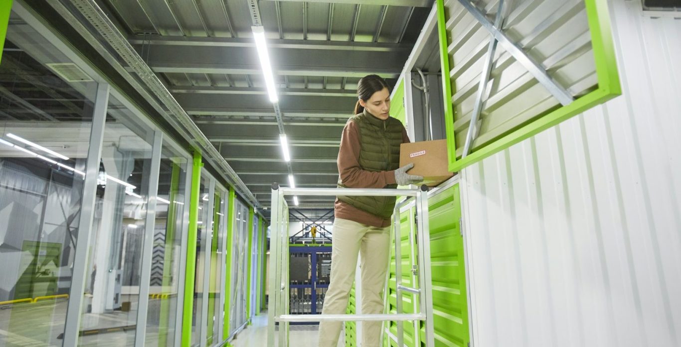 Professionelle Kommissionierung und Lagerlogistik: Mitarbeiterin verpackt Kartons im Regallager